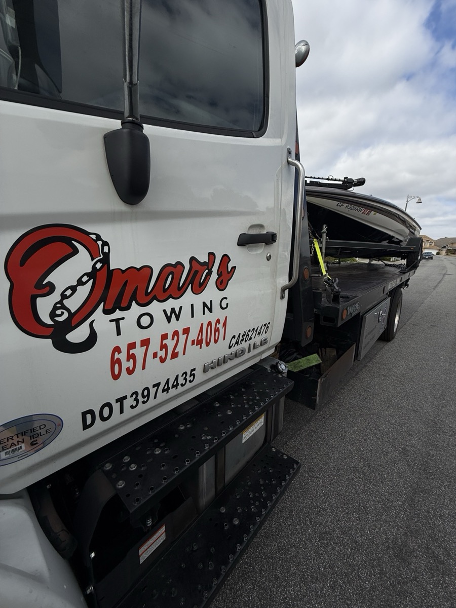Omar's Towings truck door with logo and phone number